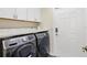 Modern laundry room features front loading washer and dryer, white cabinets and counter top at 17472 Se 112Th Ct, Summerfield, FL 34491