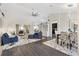 Open-concept living space with hardwood floors, stylish furnishings, and a seamless flow to dining area at 17472 Se 112Th Ct, Summerfield, FL 34491