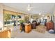 Bright sunroom featuring tile floors, a ceiling fan, desk area, and comfortable leather furniture at 17472 Se 112Th Ct, Summerfield, FL 34491