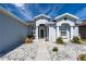 Inviting front entrance featuring a decorative glass door with white rock landscaping and lush greenery at 1813 Sw 157Th Place Rd, Ocala, FL 34473