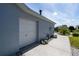 A side view of the home features a two-car garage and walkway surrounded by lush landscaping at 1813 Sw 157Th Place Rd, Ocala, FL 34473