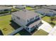 An aerial view of a house emphasizing a welcoming covered front porch, driveway, and well-manicured lawn at 1861 Ne 50Th Ter, Ocala, FL 34470