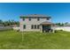 Large backyard featuring a well-kept lawn, a covered patio, and a two-story home at 1861 Ne 50Th Ter, Ocala, FL 34470