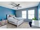 Spacious bedroom features a ceiling fan, carpet flooring, natural light, and a light blue accent wall at 1861 Ne 50Th Ter, Ocala, FL 34470