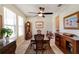 Traditional dining room featuring a wood table, chairs, large windows, and a decorative ceiling fan with light at 1861 Ne 50Th Ter, Ocala, FL 34470