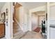 Inviting foyer with carpeted stairs, neutral walls, tiled floors, and an open doorway leading to other rooms at 1861 Ne 50Th Ter, Ocala, FL 34470