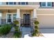 Inviting front porch with stone accents, a cozy seating area, manicured bushes and a sleek black front door at 1861 Ne 50Th Ter, Ocala, FL 34470