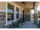 Inviting front porch featuring stone accents, a cozy seating area, and well-maintained landscaping at 1861 Ne 50Th Ter, Ocala, FL 34470