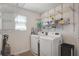 Functional laundry room with a washer, dryer, ample shelving, and natural light at 1861 Ne 50Th Ter, Ocala, FL 34470