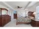 Large main bedroom with dark wood furniture, carpet flooring, ceiling fan, and ensuite bathroom access at 1861 Ne 50Th Ter, Ocala, FL 34470