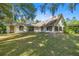 Expansive view of the home's backyard, accented by the exterior of the home with abundant windows and doors at 2130 Sw 37Th Street Rd, Ocala, FL 34471