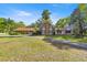 Attractive single-story home showcasing a stone facade, expansive lawn, and mature palm trees enhancing its curb appeal at 2130 Sw 37Th Street Rd, Ocala, FL 34471