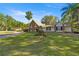 Attractive single-story home showcasing a stone facade, expansive lawn, and mature trees enhancing its curb appeal at 2130 Sw 37Th Street Rd, Ocala, FL 34471