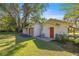 View of the detached garage and side door of the main home, accented by lush landscaping at 2130 Sw 37Th Street Rd, Ocala, FL 34471