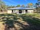 A spacious backyard featuring a lush green lawn and sliding glass doors at 22 Fisher Way Pass, Ocklawaha, FL 32179
