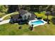 Aerial view of home with a sparkling pool, lush green lawn, and well-maintained landscaping at 2881 Se 41St Pl, Ocala, FL 34480