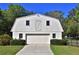 A charming barn with a two-car garage door, surrounded by green shrubbery at 2881 Se 41St Pl, Ocala, FL 34480