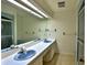 Bathroom featuring double sinks, a large mirror, and a walk-in shower at 2881 Se 41St Pl, Ocala, FL 34480
