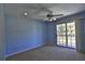 Bedroom featuring light blue walls, a ceiling fan, and a glass sliding door leading to the outside at 2881 Se 41St Pl, Ocala, FL 34480