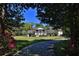 Charming two-story home with columns and a well-manicured lawn, framed by trees and vibrant pink flowers at 2881 Se 41St Pl, Ocala, FL 34480