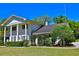 Spacious home with white columns and mature trees, offering a glimpse of its serene surroundings at 2881 Se 41St Pl, Ocala, FL 34480