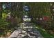 Long driveway through trees and flowers leads to a charming two-story home with a beautiful garden at 2881 Se 41St Pl, Ocala, FL 34480