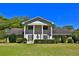 Classic two-story home with white columns, shutters, mature landscaping, and a welcoming front yard at 2881 Se 41St Pl, Ocala, FL 34480
