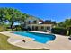 Backyard showcasing a large pool, lush green grass, and bright blue sky at 2881 Se 41St Pl, Ocala, FL 34480