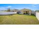 Spacious backyard with a covered patio, green lawn, and white fence, perfect for entertaining at 29496 Caspian St, Leesburg, FL 34748