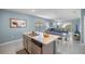 Open kitchen with stainless steel appliances and island flowing into the dining and living areas at 29496 Caspian St, Leesburg, FL 34748