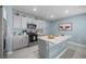 Well-lit kitchen featuring stainless steel appliances, an island, and light gray cabinetry at 29496 Caspian St, Leesburg, FL 34748