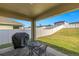 Covered patio area with a grill and patio furniture overlooking the fenced backyard at 29496 Caspian St, Leesburg, FL 34748