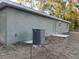 View of the exterior of a one-story house with a utility access door and an AC unit to the left side of the house at 2983 Se 145Th Pl, Summerfield, FL 34491