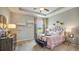 Charming bedroom features soft pink decor, tray ceiling, and a comfortable upholstered bed at 3063 Canopy Oak Blvd, Wildwood, FL 34785