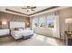 Beautiful bedroom featuring a tray ceiling, geometric accent wall, and lots of natural light at 3063 Canopy Oak Blvd, Wildwood, FL 34785