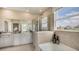 Bathroom featuring double vanity, large window, and separate bathtub and glass enclosed shower at 3067 Canopy Oak Blvd, Wildwood, FL 34785