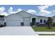Charming single-story home featuring a three-car garage, stone accents, and well-manicured lawn at 3067 Canopy Oak Blvd, Wildwood, FL 34785