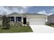 Charming one-story home with stone accents, a manicured lawn, and a two-car garage at 3088 Canopy Oak Blvd, Wildwood, FL 34785