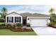 Charming single-story home with a two-car garage and manicured landscaping at 3088 Canopy Oak Blvd, Wildwood, FL 34785