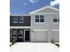 Charming two-story townhome with attached garage and neutral-colored exterior, set beneath a clear sky at 3282 Bertram Rd, Wildwood, FL 34785