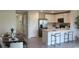Open-concept kitchen with island seating and stainless steel appliances flows into dining area at 3282 Bertram Rd, Wildwood, FL 34785