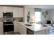 Bright kitchen with stainless steel appliances, quartz countertops, and seamless flow to the living area at 3282 Bertram Rd, Wildwood, FL 34785