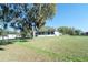 Green backyard showing exterior and screened porch of the house at 390 Sw Shorewood Dr, Dunnellon, FL 34431
