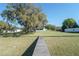 Waterfront property featuring a home with a dock and large mossy oak trees shading the expansive front lawn at 390 Sw Shorewood Dr, Dunnellon, FL 34431