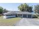 A sunny shot of a one story house, featuring a two-car garage and a well-manicured lawn at 390 Sw Shorewood Dr, Dunnellon, FL 34431