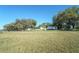 Property view showing the house, lush lawn, and storage buildings at 390 Sw Shorewood Dr, Dunnellon, FL 34431