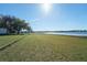 Wide expanse of grassy lawn leading to a private lakefront dock, offering a serene and picturesque setting for outdoor enjoyment at 390 Sw Shorewood Dr, Dunnellon, FL 34431