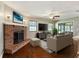 Cozy living room with a brick fireplace, hardwood floors, and a ceiling fan at 4541 Sw 44Th Ln, Ocala, FL 34474