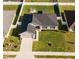 Aerial view of a single-story home showcasing dark-grey roof, green lawn, and backyard seating area at 5001 Sw 91St Pl, Ocala, FL 34476