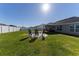 Grassy backyard features an outdoor seating area and a white vinyl fence for privacy at 5001 Sw 91St Pl, Ocala, FL 34476